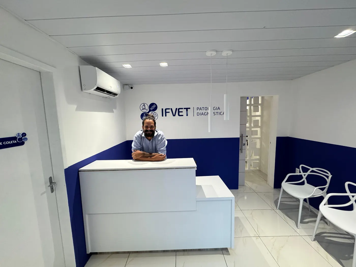 Recepção do IFVET, com balcão branco, paredes em azul e o logotipo do laboratório